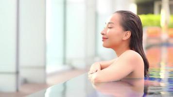 Young woman enjoys around outdoor swimming pool video