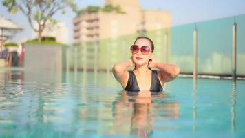 mujer joven disfruta alrededor de la piscina al aire libre video