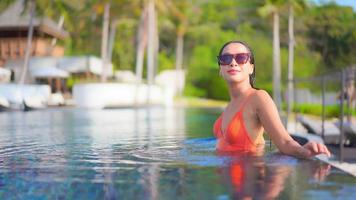 mujer joven disfruta alrededor de la piscina al aire libre video