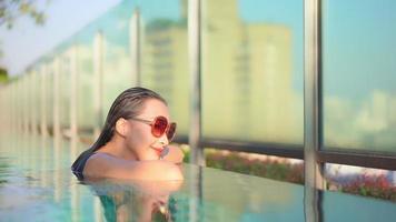 Young woman enjoys around outdoor swimming pool video