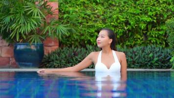 mujer joven disfruta alrededor de la piscina al aire libre video