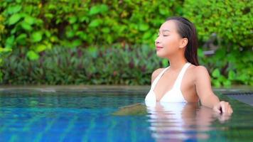 Young woman enjoys around outdoor swimming pool