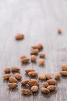 Almonds Scattered On Wood Background Vertical photo