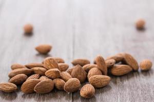 Almonds Scattered on Wood Background photo