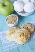 Pequeñas tartas de manzana con azúcar cruda y huevos verticales foto