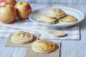 manzanas rojas y tartas de mano con cuchara de madera foto