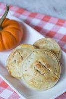 Tartas de manzana y calabaza en una servilleta a cuadros rojos foto