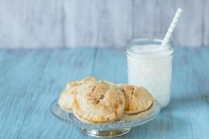 Apple Hand Pies On Antique Glass Plate With Milk photo