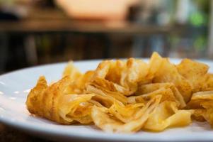 Stack of fried crispy roti indian bread on white plate with sweet milk photo