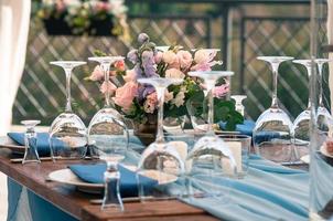 Event decoration table setup, blue napkins, flowers, outdoors photo