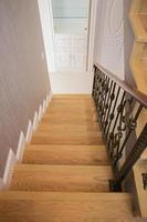 Staircase, wooden floor and black iron rail. photo