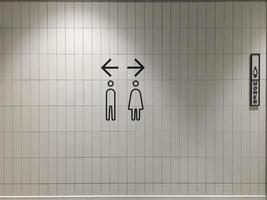A sign that shows the way to the bathroom in a mall. photo