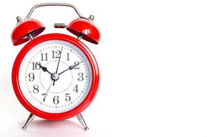 Red round analog alarm clock isolated on white background. Time 10 10 photo