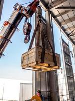 The crane carrying a wooden box of radioactive package to the plant photo