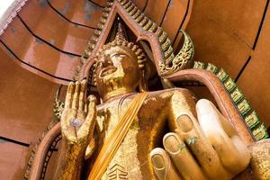 Silver chrysanthemum symbol and goldleaf In the palm of Buddha statue photo