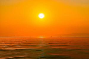 puesta de sol naranja brillante sobre el mar foto