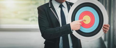 Business Man is Pointing Goal Target on Dartboard photo