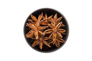 Star anise in clay bowl isolated on white background photo