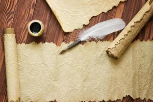 Papel antiguo, pergamino y pluma sobre papel de madera con espacio de copia