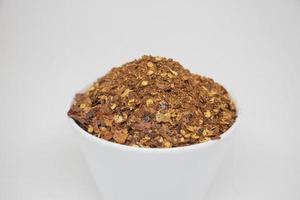 dried red chillies in a white cup on a white background photo