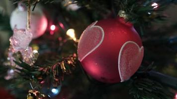 Close up angel ornament and heart shaped balls on christmas tree video