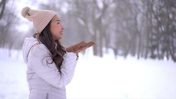 ung asiatisk kvinna njuter av leende runt snö och vinter video