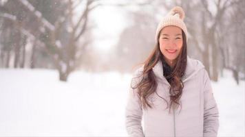 jonge aziatische vrouw geniet van een glimlach rond sneeuw en winter video