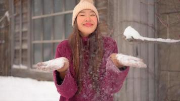 la giovane donna asiatica gode del sorriso intorno alla neve e all'inverno?