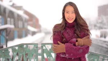 jeune femme asiatique aime sourire autour de la neige et de l'hiver