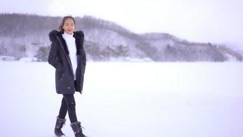 jonge aziatische vrouw geniet van een glimlach rond sneeuw en winter