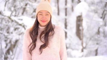 junge asiatische frau genießt lächeln um schnee und winter video