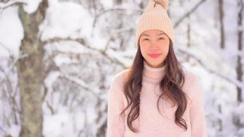 jonge aziatische vrouw geniet van een glimlach rond sneeuw en winter video