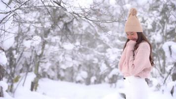 junge asiatische frau genießt lächeln um schnee und winter video