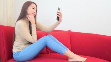jeune femme asiatique à l'aide d'un smartphone video