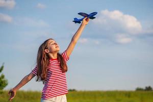 joven adolescente sosteniendo un avión. concepto de sueño foto