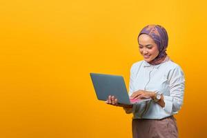 Portrait of smiling Asian woman holding laptop photo