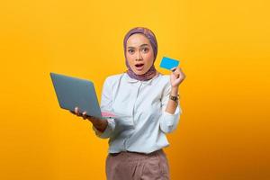 Surprised Asian woman holding laptop and showing blank car photo