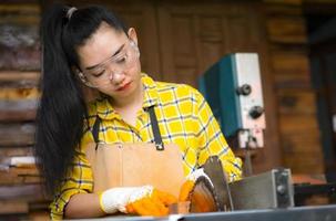 Woman is craft working cut wood with circular saws power tools photo
