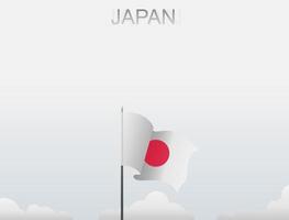 bandera de japón volando bajo el cielo blanco vector