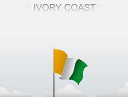 Flag of Ivory Coast flying under the white sky vector