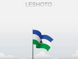 Flag of Lesotho flying under the white sky vector