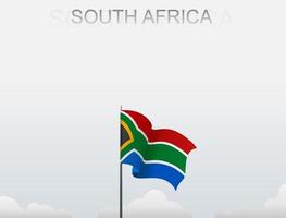 bandera de sudáfrica volando bajo el cielo blanco