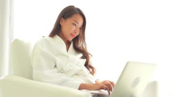 jovem mulher asiática usando um laptop no sofá video