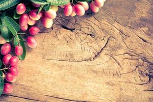 Miracle fruit on old wooden table photo