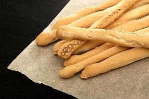 Bread sticks lie on baking paper. Place under the text