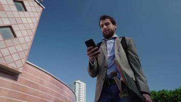 Young bearded male businessman ride on skateboard outdoors video