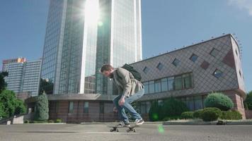 ung skäggig manlig affärsman åka på skateboard utomhus video