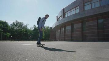 Jeune homme d'affaires barbu ride sur skateboard en plein air video