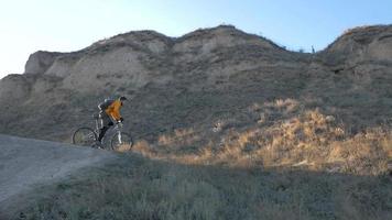 Young male bicycle rider travel on the hills in summer sunny day video