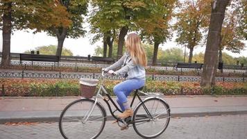 giovane donna con bicicletta retrò all'aperto video